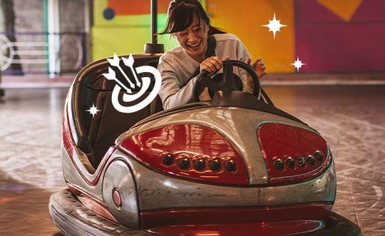 mulher asiática pilotando carrinho de brinquedo "bate-bate"